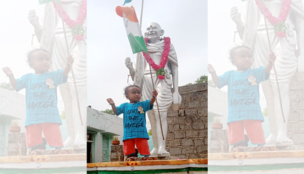 A-child-with-a-tricolor-flag-in-front-of-the-father-of-the-nation