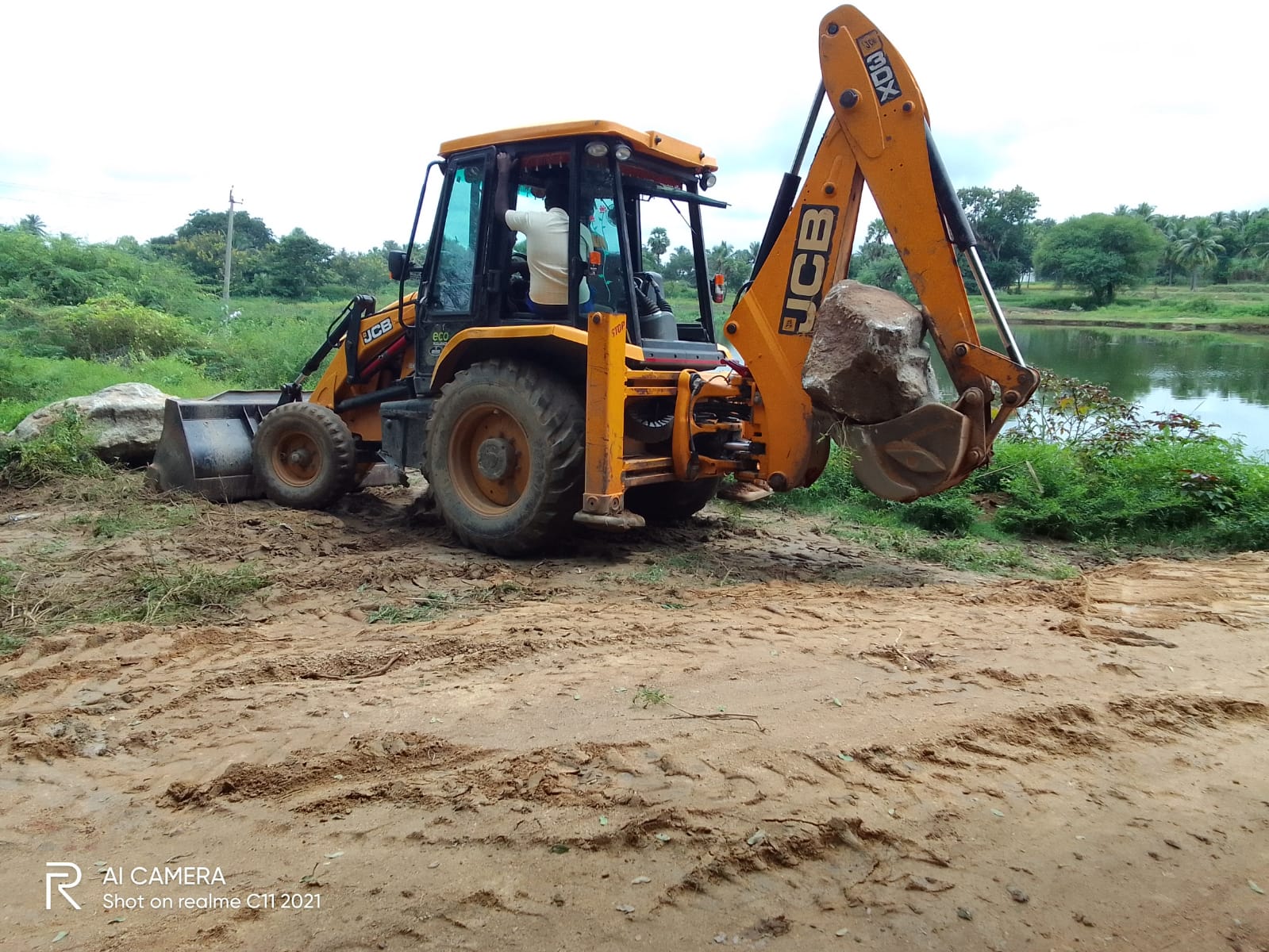 జేసిబితో ఆక్రమణలు తొలగిస్తున్న రెవెన్యూ సిబ్బంది