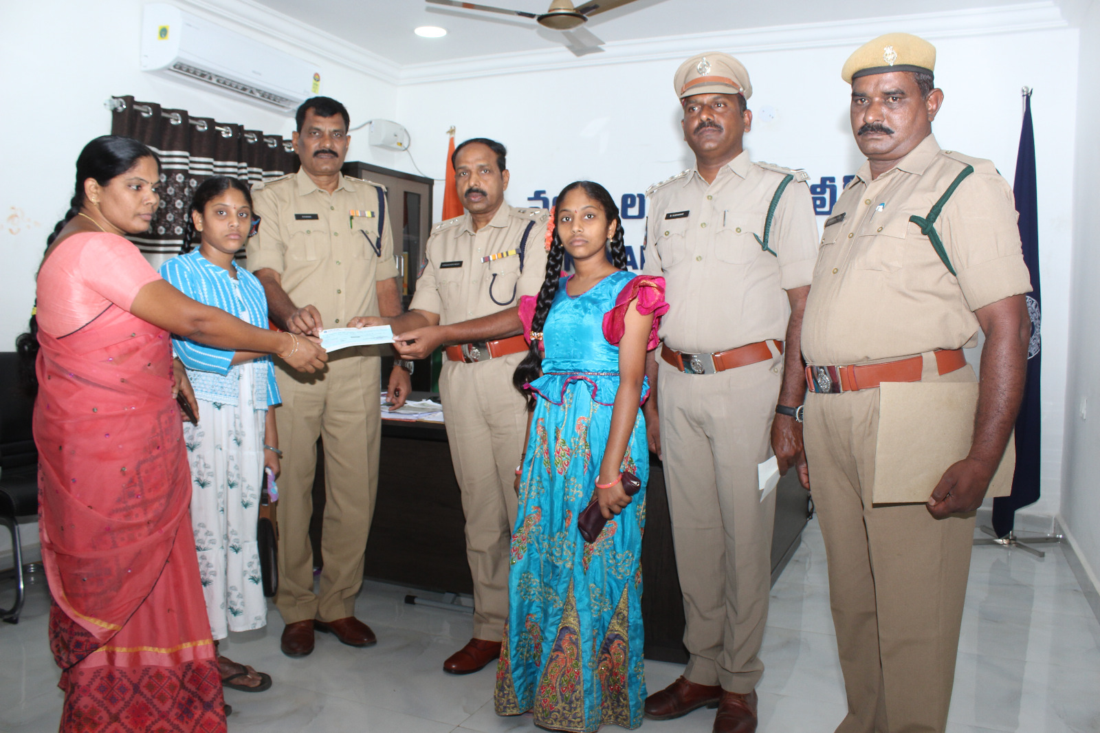 బాధిత కుటుంబాలకు చెక్కు అందజేస్తున్న జిల్లా ఎస్పీ, తదితరులు