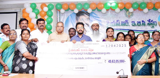 మహిళలకు చెక్కు అందజేస్తున్న కలెక్టర్‌ గిరీష