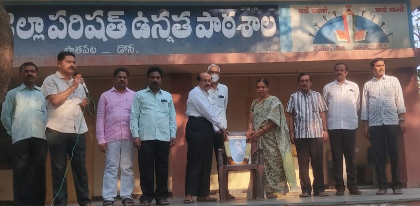 చార్లెస్ రాబర్ట్ డార్విన్ చిత్రపటానికి పూలమాలలు వేసి నివాళులర్పిస్తున్న ఉపాధ్యాయులు