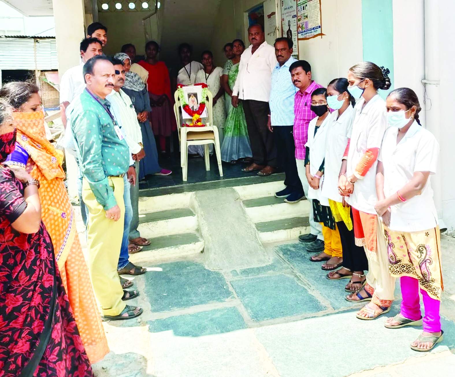 మృతుని చిత్రపటానికి పూలమాల వేసి నివాళులర్పిస్తున్న వైద్య ఉద్యోగులు