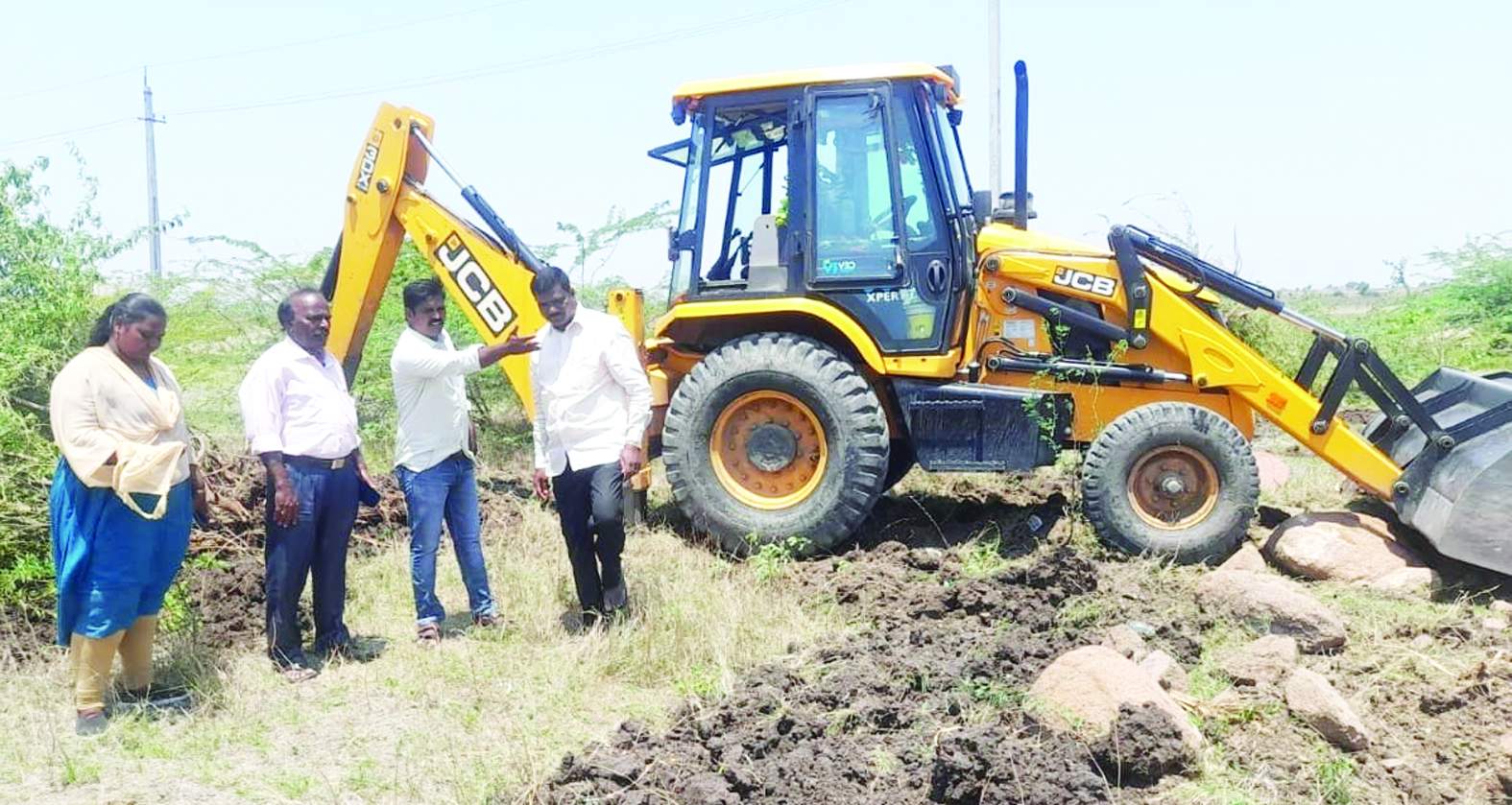 జగనన్న కాలనీలో జెసిబి ద్వారా ముళ్లకంపను తొలగిస్తున్న అధికారులు