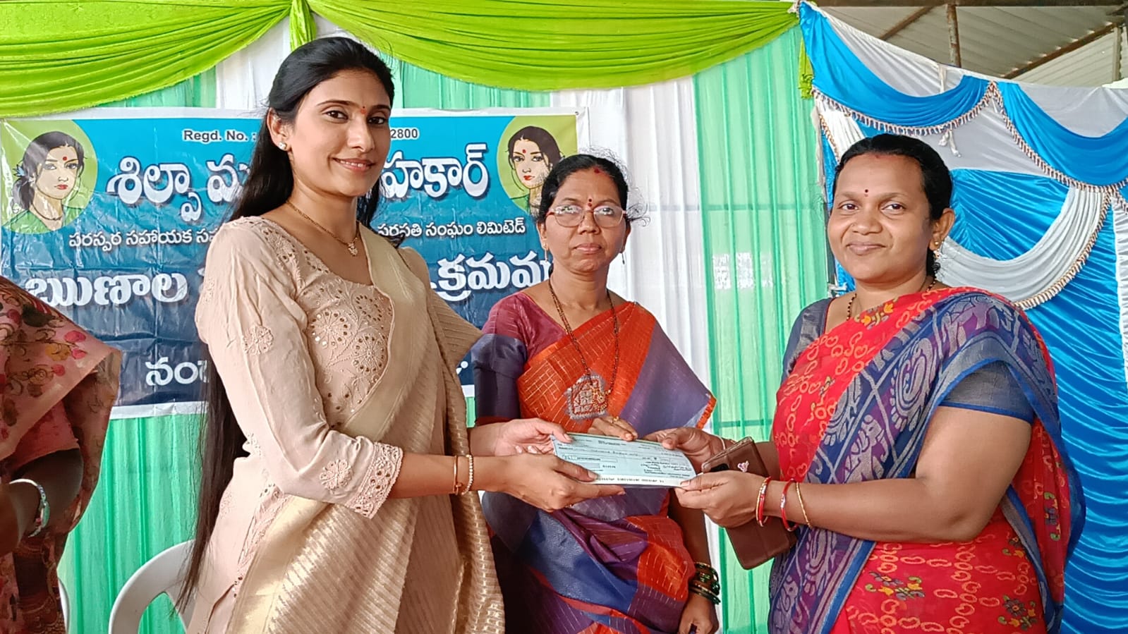 మహిళలకు చెక్కులు పంపిణీ చేస్తున్న నాగిని రవి సింగారెడ్డి