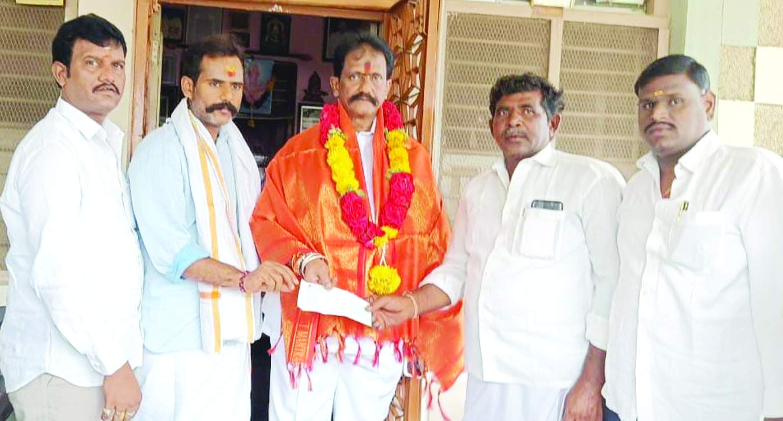 బాధితులకు చెక్కును అందజేస్తున్న ఎమ్మెల్యే