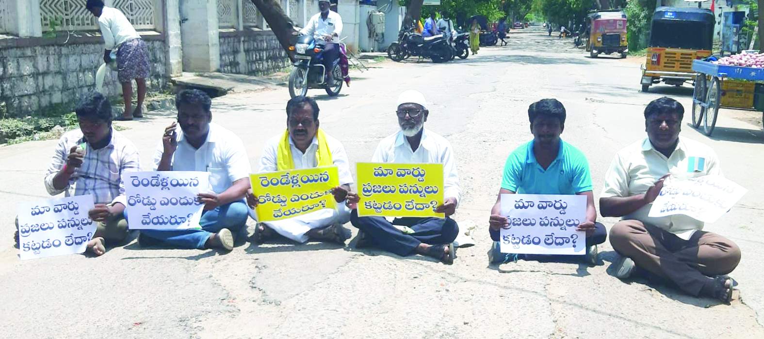 రోడ్డుపై ఫ్లకార్డులు ప్రదర్శిస్తూ నిరసన తెలుపుతున్న నాయకులు