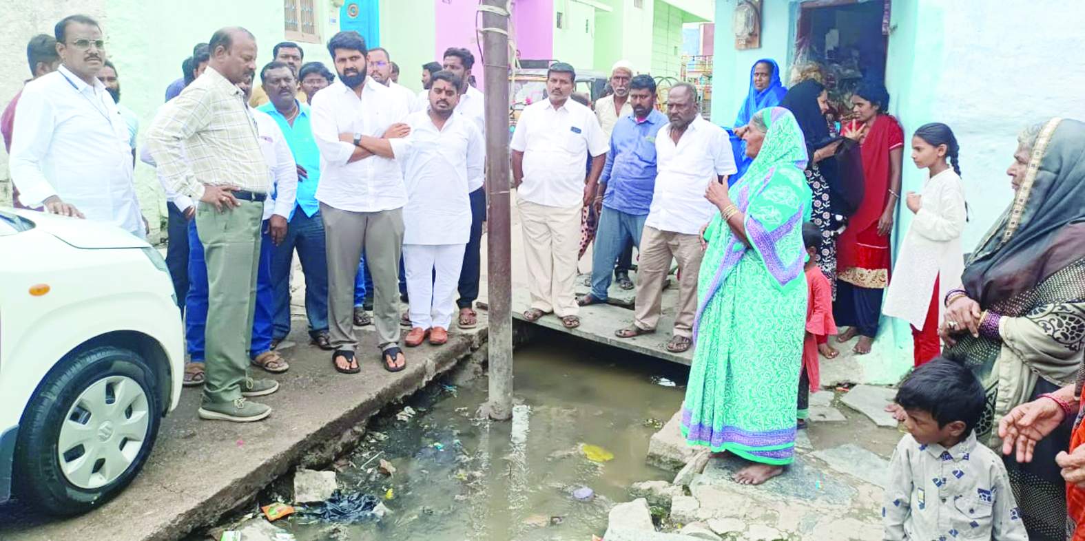 మురుగు కాలువలో పూడిక తొలగించాలని విజ్ఞప్తి చేస్తున్న మహిళ