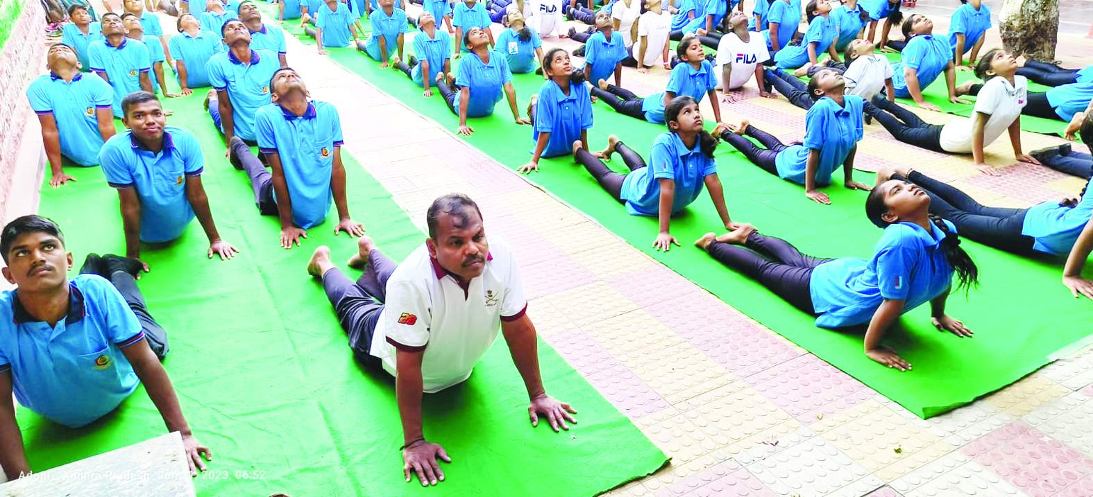 యోగా చేస్తున్న సిబ్బంది, విద్యార్థులు