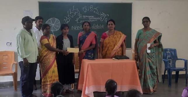 విద్యార్థులకు బహుమతి అందజేస్తున్న సర్పంచ్ సుజాత, ప్రిన్సిపాల్ వెంకటరమణమ్మ