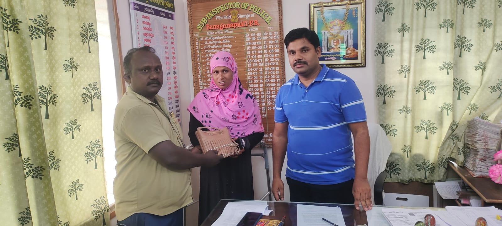 బాధితురాలికి బ్యాగ్ అందజేస్తున్న ఆటో డ్రైవర్