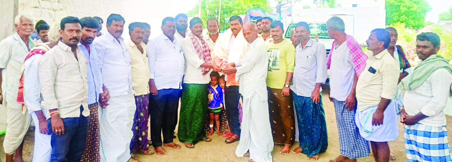 సంగాల గ్రామ పెద్దలకు నగదను అందజేస్తున్న విరుపాక్షి