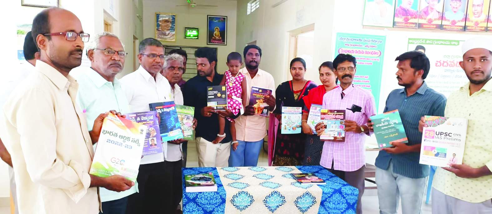 పుస్తకాలను గ్రంథాలయ అధికారికి అందజేస్తున్న భీమన్న