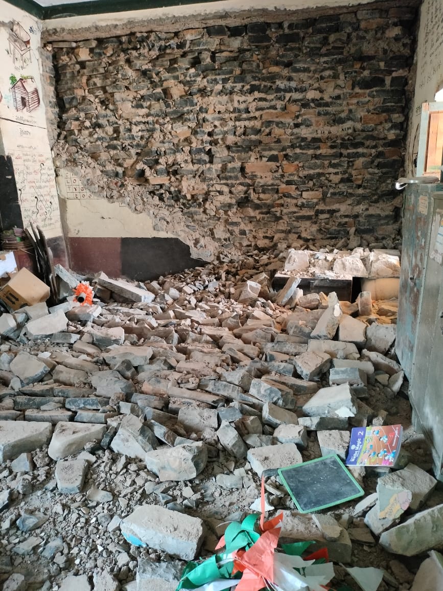 పాఠశాల గోడ కూలి విద్యార్థుల బ్యాగులు పుస్తకాల మీద పడిన దృశ్యం