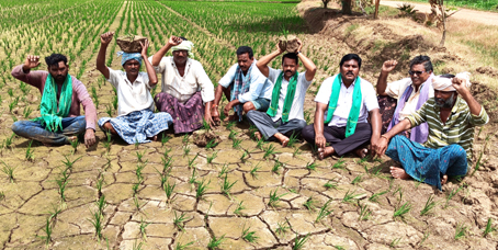 ఎండిన వరి దుబ్బులతో రైతుల లనిరసన