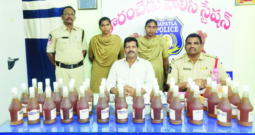 స్వాధీనం చేసుకున్న మద్యం బాటిళ్లతో సిఐ, ఎస్‌ఐలు