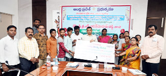 .లబ్ధిదారులకు చెక్‌ను అందజేస్తున్న కలెక్టర్‌ గిరీష