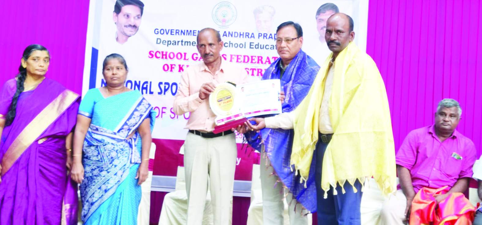 డిఇఒ చేతుల మీదుగా అవార్డు అందుకుంటున్న చినబాబు