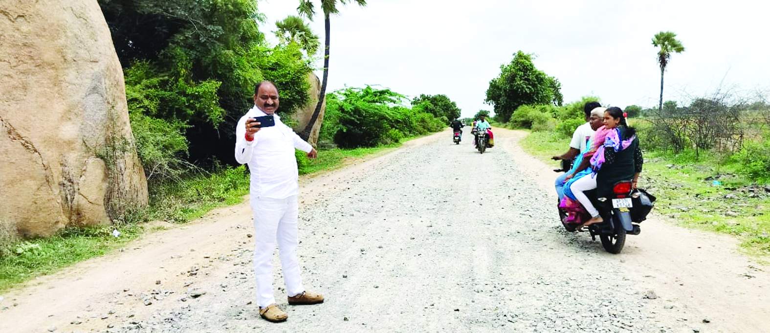 అధ్వానస్థితిలో ఉన్న రోడ్డును చూపుతున్న తిక్కారెడ్డి