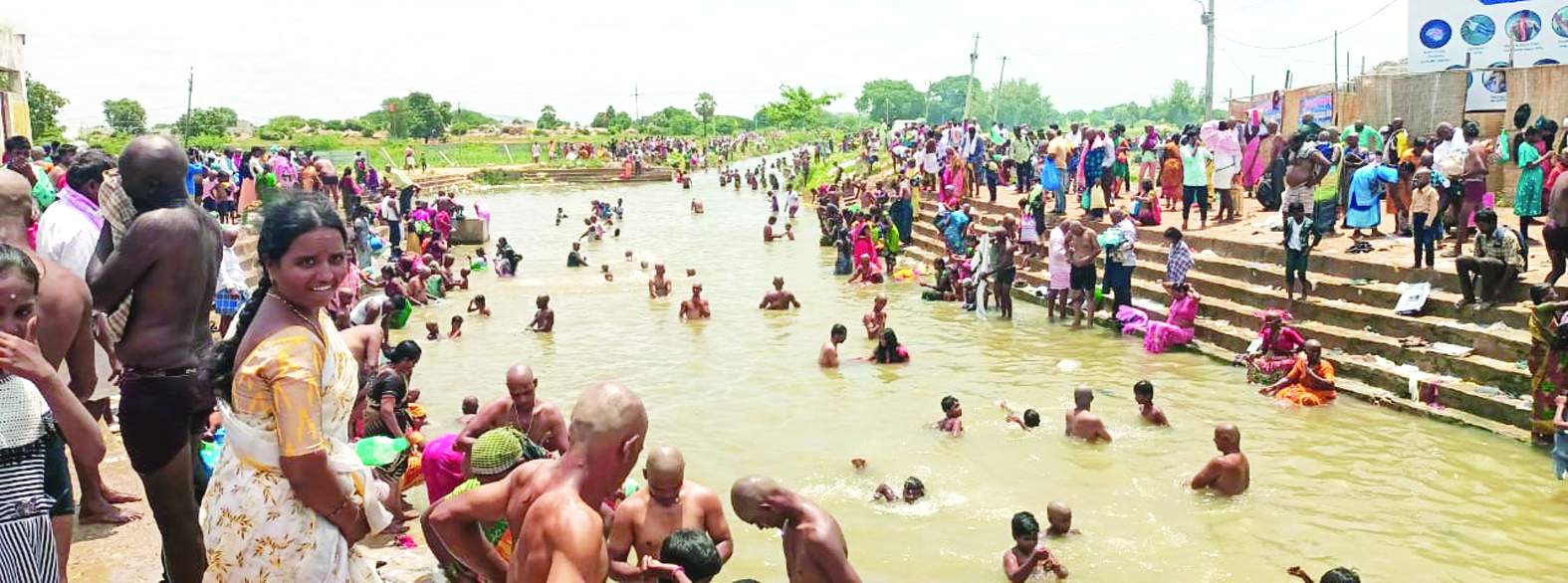 కాలువలో స్నానాలు చేస్తున్న భక్తులు