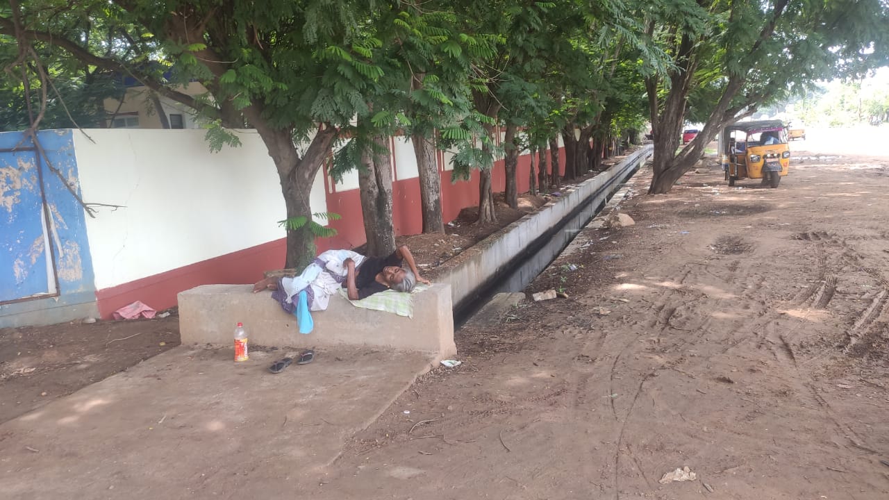 ఆస్పత్రిలో విశ్రాంతి తీసుకునే స్థలం లేక మురుగు కాల్వ గట్టుపై పడుకున్న రోగుల బంధువులు 