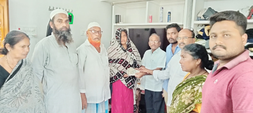 బీమా నగదు అందజేస్తున్న నాయకులు