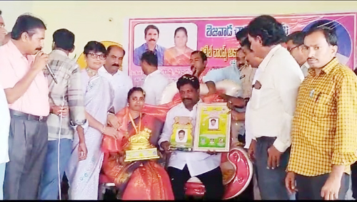 అవార్డును అందుకుంటున్న యన్నం సురేష్ దంపతులు
