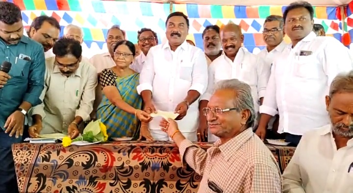 జంపనిలో ఉద్యోగులకు చెక్కులు అందజేస్తున్న మంత్రి నాగార్జున