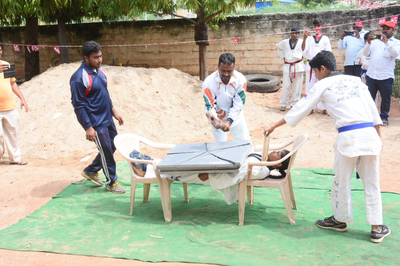 క్రీడాకారిణిపై బండలు పెట్టి పగలగొట్టి విన్యాసాలను చేస్తున్న కోచ్‌ జి.షబ్బీర్‌ హుస్సేన్‌