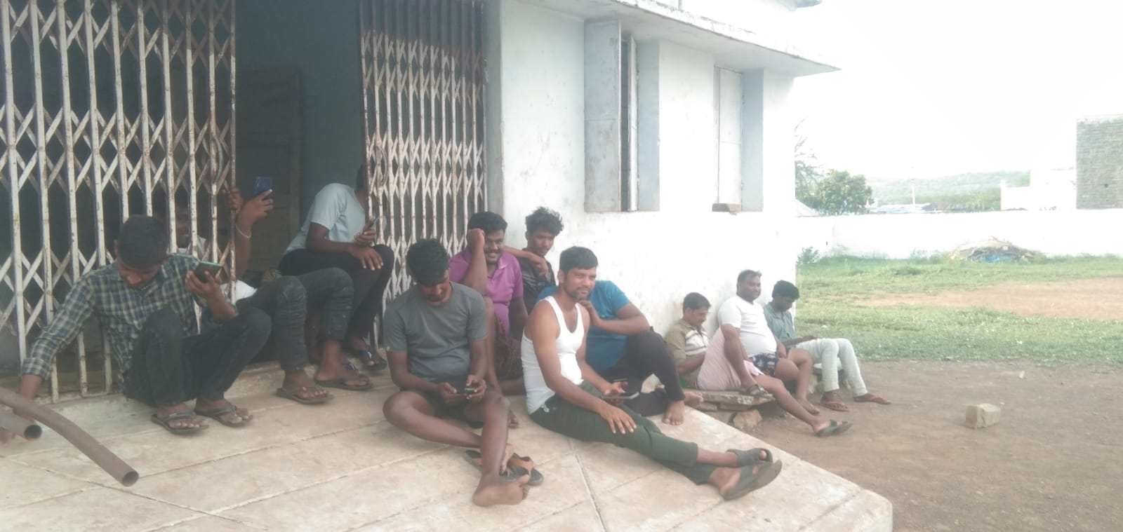 నీడ ఉన్న చోట కూర్చున్న యువకులు